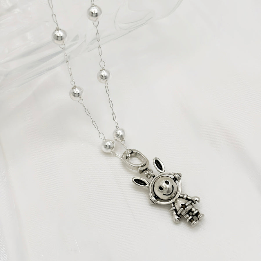 This necklace features a whimsical astronaut bunny with a double-sided, rotating face crafted from 925 sterling silver. With one side depicting a cheerful smile and the other showing a unhappy expression, it adds a playful and versatile touch to your jewelry collection. 