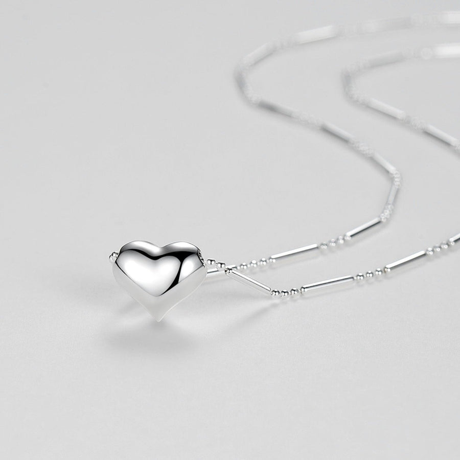 This 925 silver necklace features a puffy heart pendant in a sleek texture and high-shine polished finish. Paired with a delicate beaded chain, this necklace combines subtle texture with sophisticated charm.