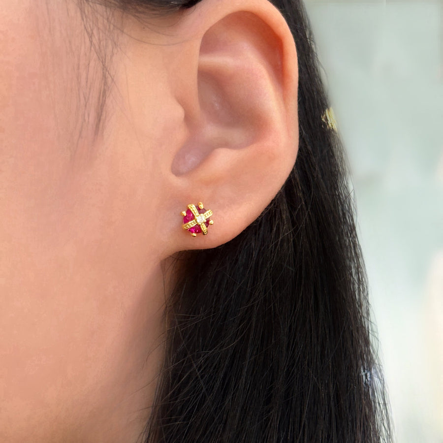 These exquisite crown-shaped earrings feature a vibrant red cubic zircon at their center, elegantly adorned with intricate gold detailing and sparkling accents. Perfect for adding a touch of elegance to any outfit, these earrings are a stunning blend of luxury and sophistication.