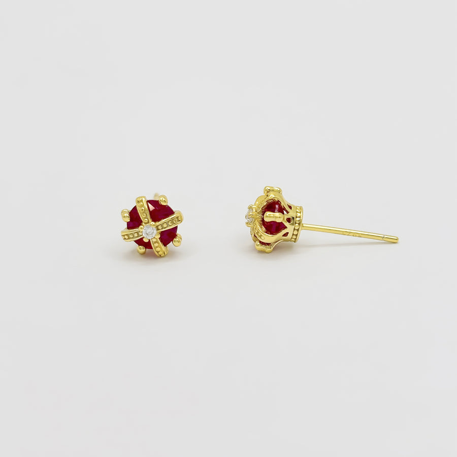 These exquisite crown-shaped earrings feature a vibrant red cubic zircon at their center, elegantly adorned with intricate gold detailing and sparkling accents. Perfect for adding a touch of elegance to any outfit, these earrings are a stunning blend of luxury and sophistication.