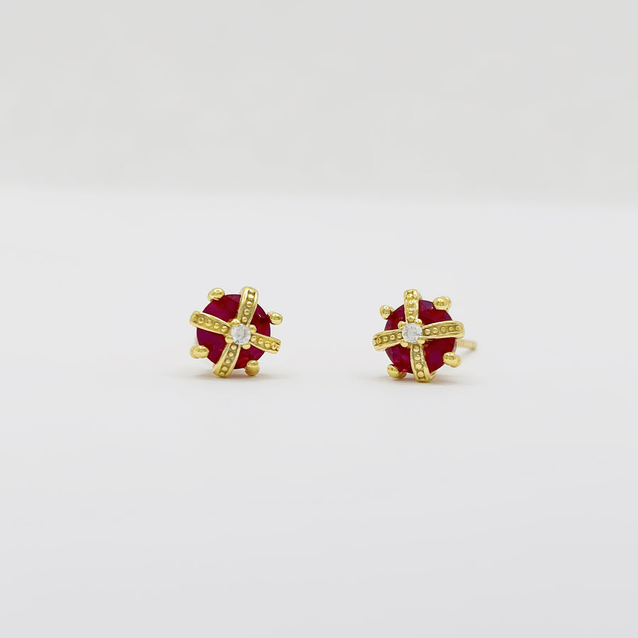 These exquisite crown-shaped earrings feature a vibrant red cubic zircon at their center, elegantly adorned with intricate gold detailing and sparkling accents. Perfect for adding a touch of elegance to any outfit, these earrings are a stunning blend of luxury and sophistication.