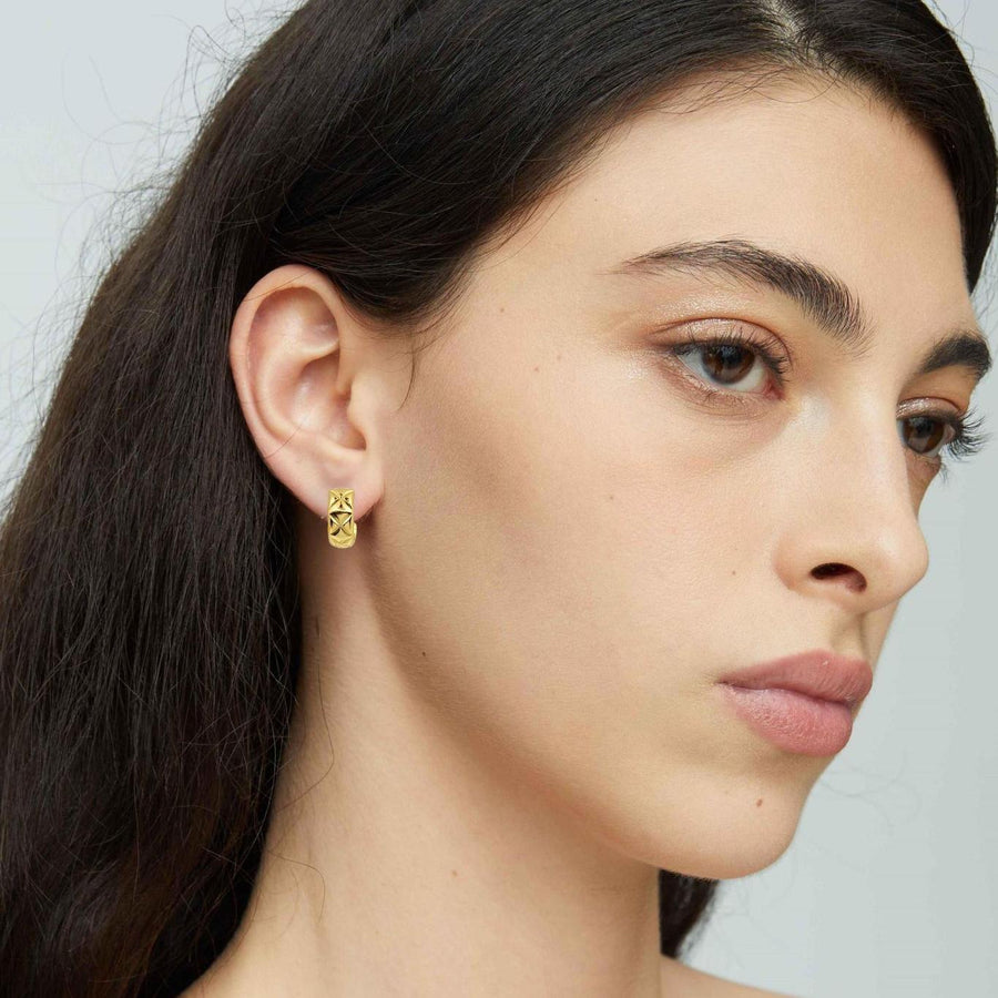 These elegant gold hoop earrings feature a unique geometric pattern, adding a touch of sophistication to any outfit. Perfect for both casual and formal occasions, these earrings are a must-have accessory for any jewelry collection.