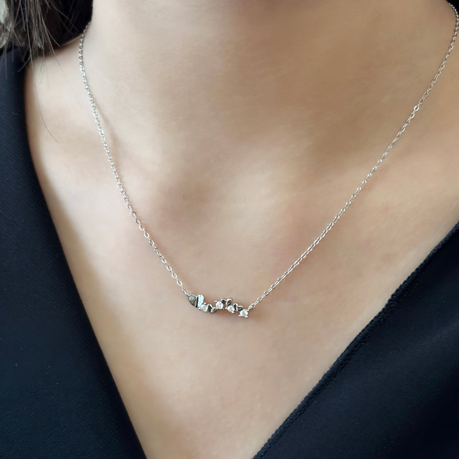 This elegant necklace features a delicate gold chain adorned with a series of small gold hearts interspersed with sparkling cubic zircon. The design is both charming and sophisticated, making it a perfect accessory for any occasion. 