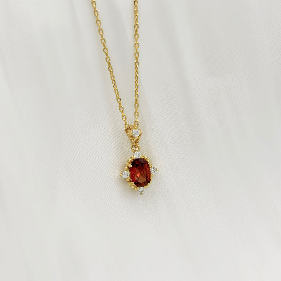 This elegant necklace features a stunning red cubic zircon set in a delicate gold chain. The central gemstone is surrounded by small, sparkling cubic zircon, adding a touch of sophistication and brilliance to the piece. Perfect for special occasions or everyday wear, this necklace combines timeless elegance with modern charm.