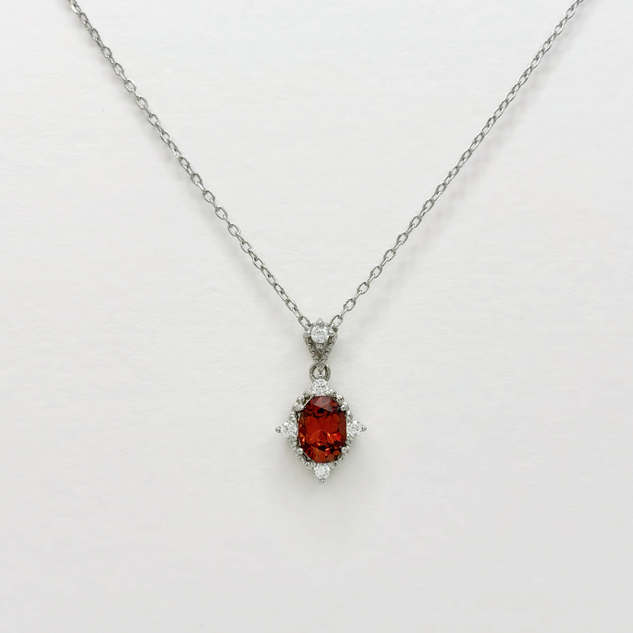 This elegant necklace features a stunning red cubic zircon set in a delicate silver chain. The central gemstone is surrounded by small, sparkling cubic zircon, adding a touch of sophistication and brilliance to the piece. Perfect for special occasions or everyday wear, this necklace combines timeless elegance with modern charm.