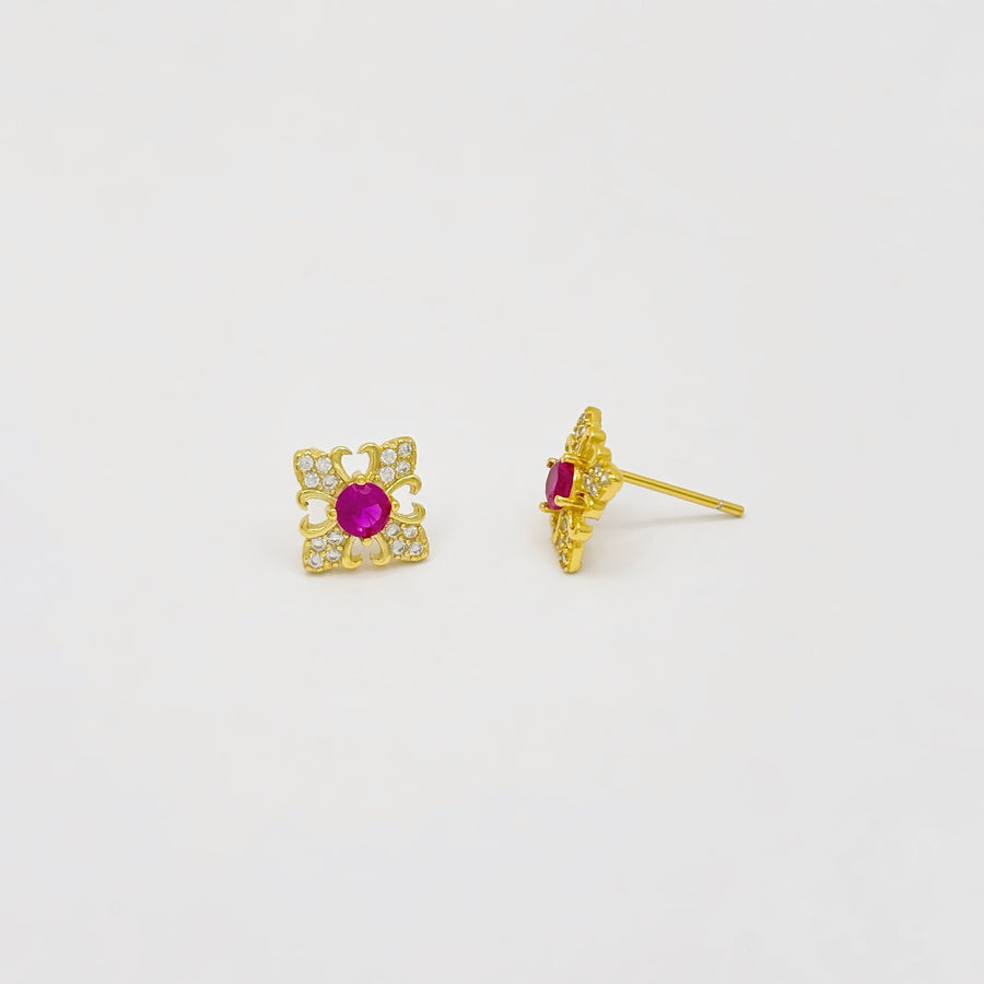 These exquisite earrings feature a central round ruby cubic zircon, surrounded by a delicate gold floral design. The petals are adorned with sparkling cubic zircon, creating a luxurious and elegant look. Perfect for special occasions or adding a touch of elegance to your everyday style, these earrings are a timeless addition to any jewelry collection. 