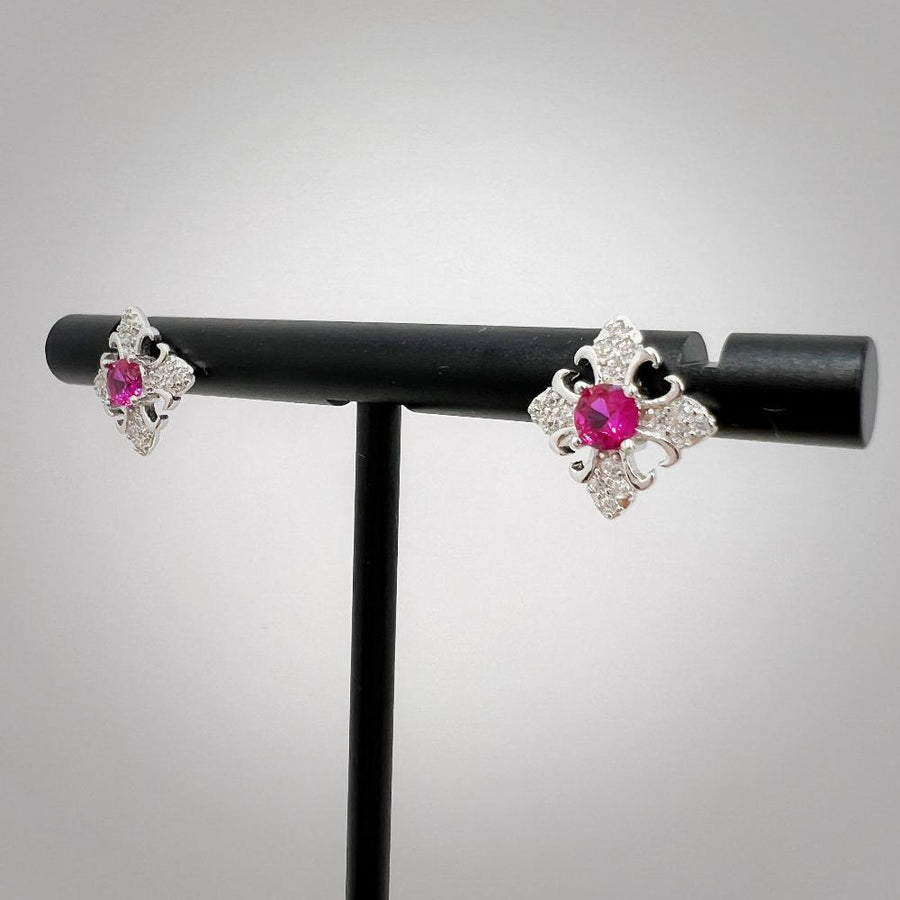 These exquisite earrings feature a central round ruby cubic zircon, surrounded by a delicate gold floral design. The petals are adorned with sparkling cubic zircon, creating a luxurious and elegant look. Perfect for special occasions or adding a touch of elegance to your everyday style, these earrings are a timeless addition to any jewelry collection. 