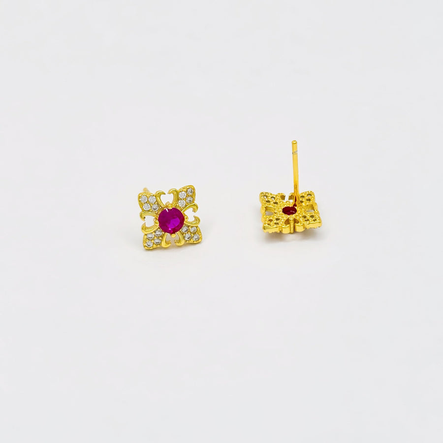 These exquisite earrings feature a central round ruby cubic zircon, surrounded by a delicate gold floral design. The petals are adorned with sparkling cubic zircon, creating a luxurious and elegant look. Perfect for special occasions or adding a touch of elegance to your everyday style, these earrings are a timeless addition to any jewelry collection. 