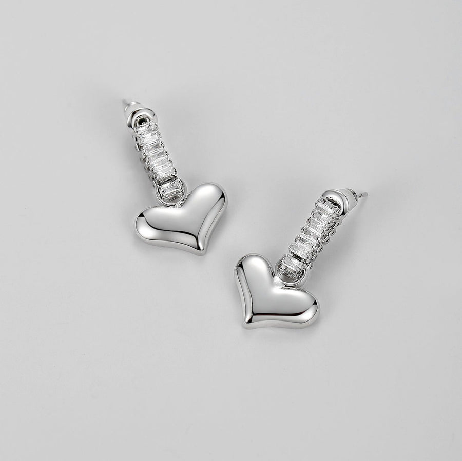 Crafted from high-quality materials, these earrings feature a glossy gold heart paired with sparkling cubic zirconia, creating a perfect balance of sophistication and playfulness. Lightweight and versatile, they are suitable for everyday wear or special occasions, making them an ideal addition to your jewelry collection.