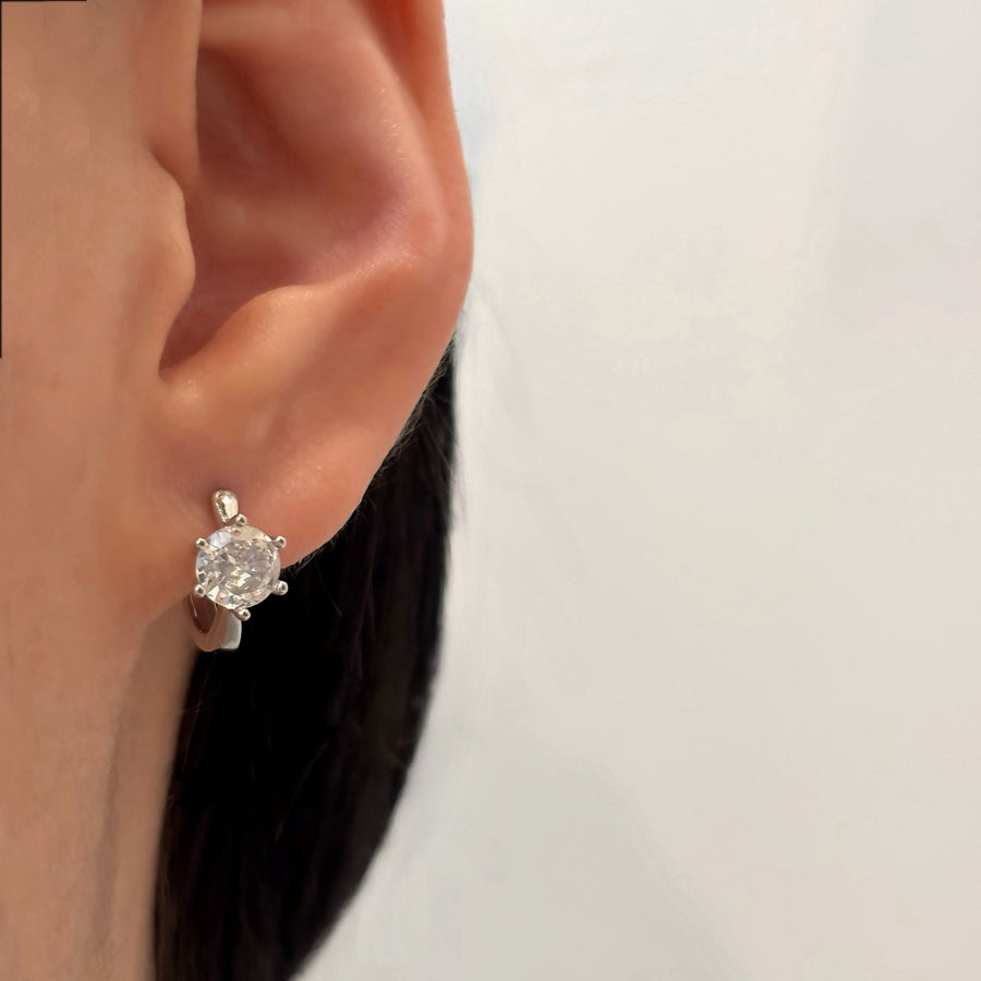 These exquisite hoop earrings feature a brilliant solitaire cubic zircon set in a sleek, silver-tone metal, adding a touch of sophistication to any look. Perfect for any occasion, these timeless and versatile earrings elevate both casual and formal outfits with their elegant sparkle.