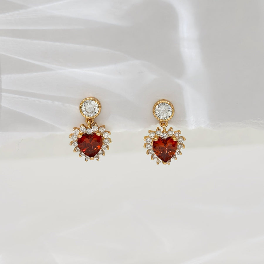 These exquisite 925 silver earrings feature a stunning heart-shaped red cubic zircon, surrounded by a halo of sparkling white cubic zircon, adding a touch of elegance and romance to any outfit. Perfect for any occasions.