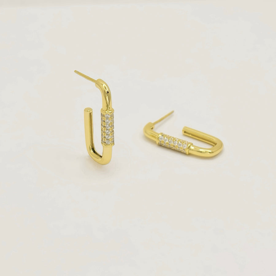 These elegant gold earrings feature a unique U-shaped design adorned with sparkling diamonds, adding a touch of sophistication to any outfit. Perfect for both casual and formal occasions, these earrings are crafted to provide a timeless and luxurious appeal.