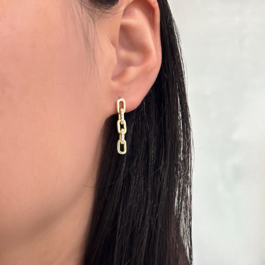 The earrings showcase a refined chain-link design adorned with shimmering set cubic zircon. These graceful, modern earrings combine timeless sophistication with a touch of sparkle, perfect for elevating both everyday and evening looks.