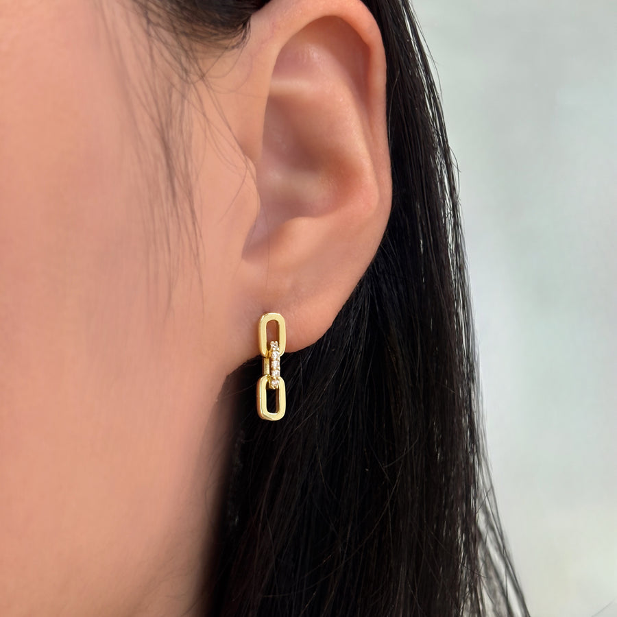 The earrings showcase a refined chain-link design adorned with shimmering set cubic zircon. These graceful, modern earrings combine timeless sophistication with a touch of sparkle, perfect for elevating both everyday and evening looks.