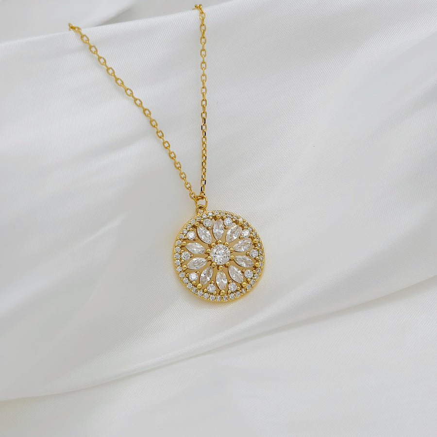 Handcrafted in gold vermeil. This stunning gold necklace features a circular pendant with a floral design, adorned with sparkling cubic zircon that add elegance and brilliance to any look.