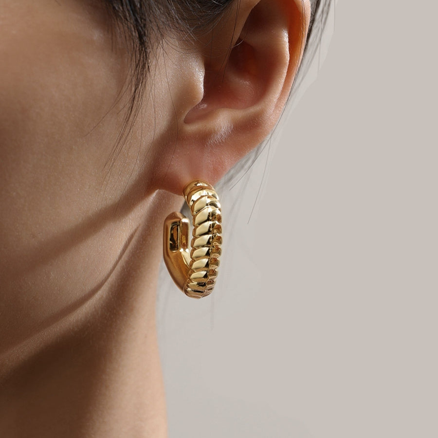 Redefine modern sophistication with our twisted elegance hoop earrings. Featuring a sleek, gold-tone finish and a unique twisted rope design, these earrings add a bold yet refined touch to any outfit. Their semi-open hoop style offers a contemporary spin on the classic hoop, making them a statement piece perfect for both casual and formal occasions.