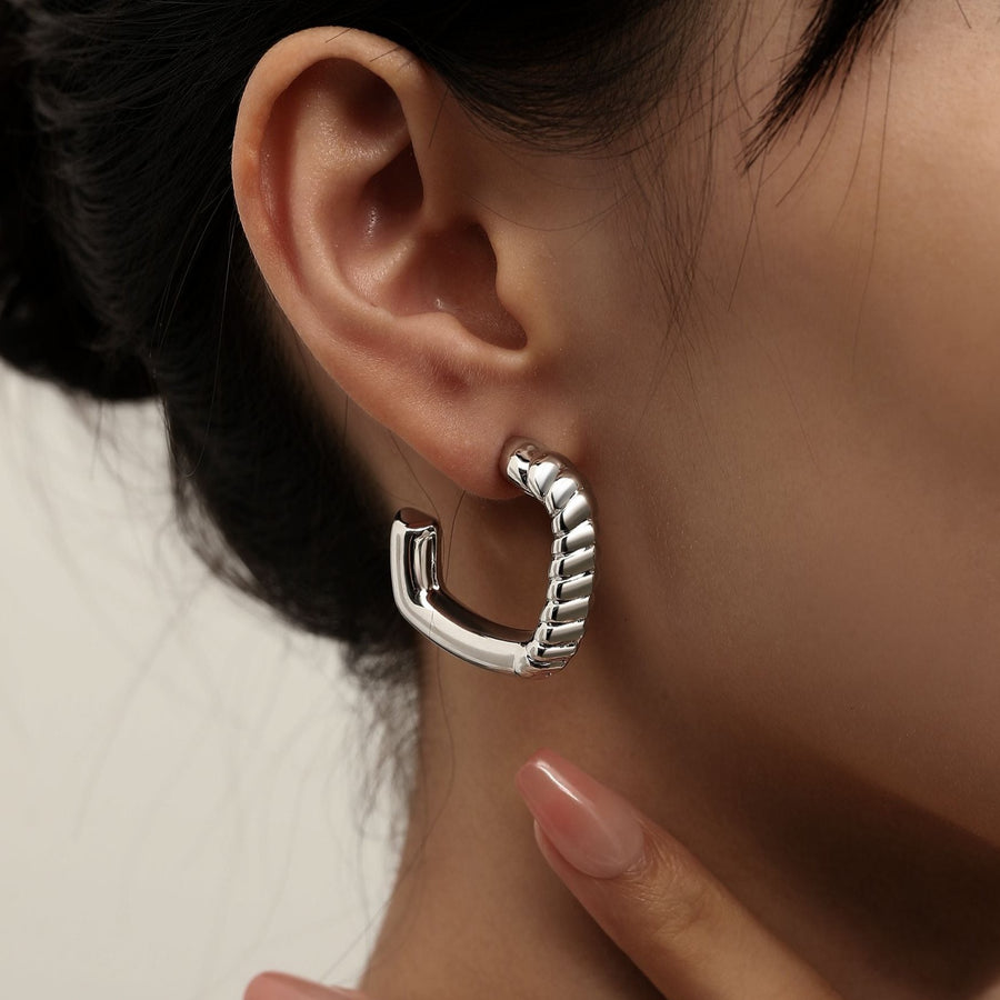 Redefine modern sophistication with our twisted elegance hoop earrings. Featuring a sleek, gold-tone finish and a unique twisted rope design, these earrings add a bold yet refined touch to any outfit. Their semi-open hoop style offers a contemporary spin on the classic hoop, making them a statement piece perfect for both casual and formal occasions.