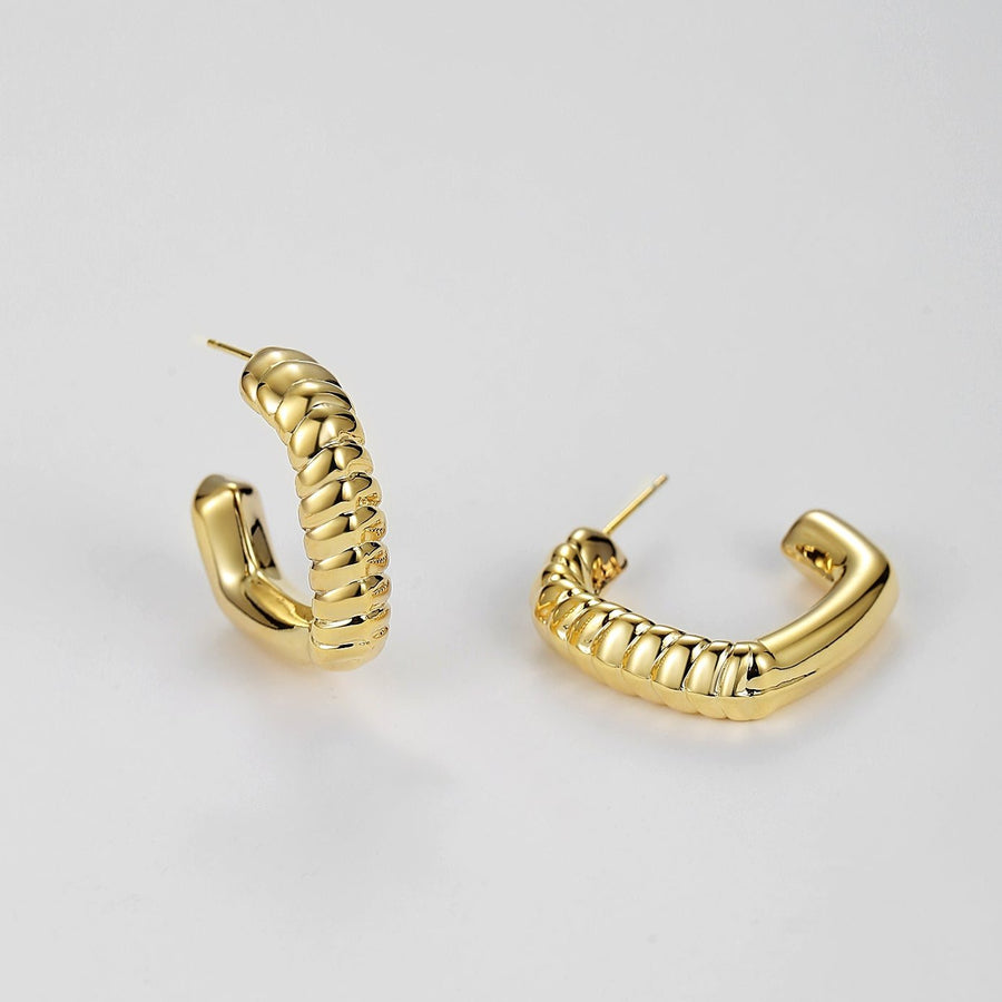 Redefine modern sophistication with our twisted elegance hoop earrings. Featuring a sleek, gold-tone finish and a unique twisted rope design, these earrings add a bold yet refined touch to any outfit. Their semi-open hoop style offers a contemporary spin on the classic hoop, making them a statement piece perfect for both casual and formal occasions.