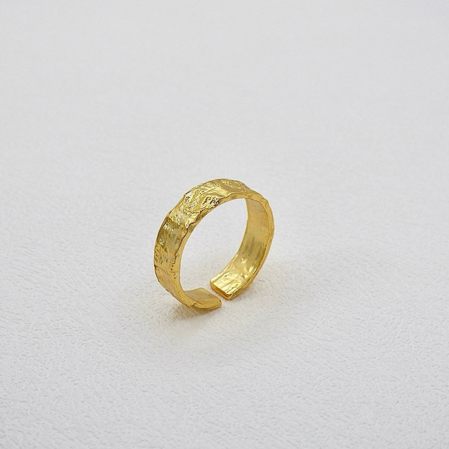 This Classic Gold Flat Band Ring showcases a refined hammered finish, adding a unique artisanal touch to a minimalist design. Designed for versatility, its open-end design ensures a perfect fit for any finger size, making it a staple in any jewelry collection.