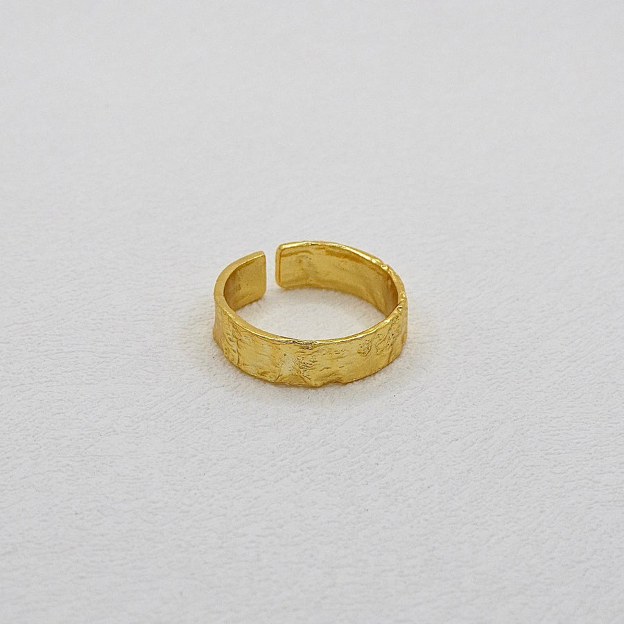 This Classic Gold Flat Band Ring showcases a refined hammered finish, adding a unique artisanal touch to a minimalist design. Designed for versatility, its open-end design ensures a perfect fit for any finger size, making it a staple in any jewelry collection.