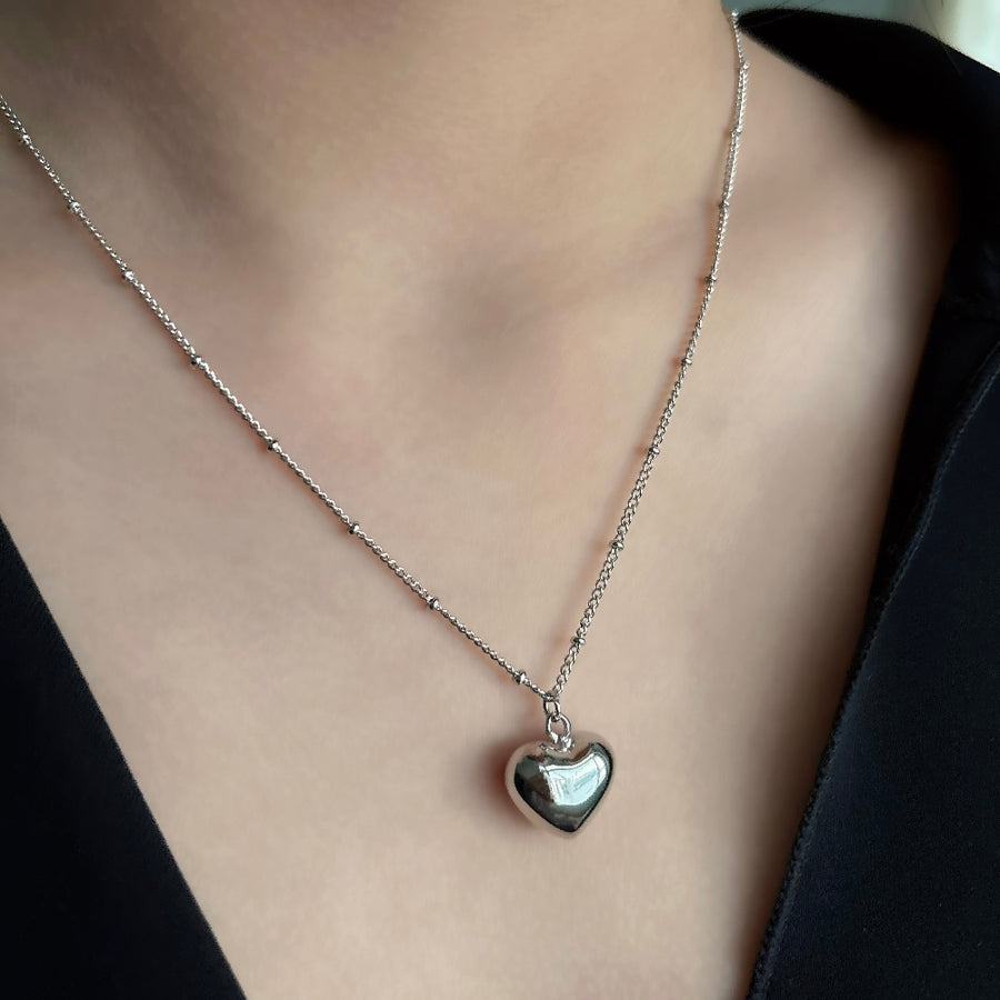 This silver heart-shaped pendant necklace is a timeless and elegant accessory. Crafted from pure sterling silver, it exudes a classic and understated charm. Perfect for any occasion, it adds a touch of sophistication to any outfit. 