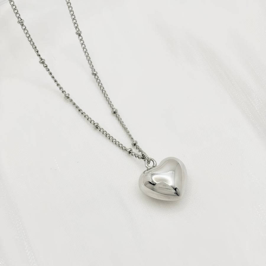 This silver heart-shaped pendant necklace is a timeless and elegant accessory. Crafted from pure sterling silver, it exudes a classic and understated charm. Perfect for any occasion, it adds a touch of sophistication to any outfit. 