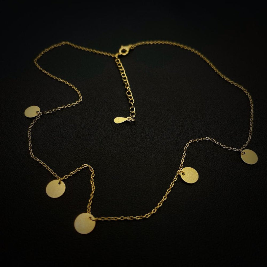 This dainty gold-plated silver necklace features delicate circular pendants, adding a touch of minimalistic charm to any outfit. Perfect for layering or wearing alone, this necklace complements both casual and formal looks effortlessly.